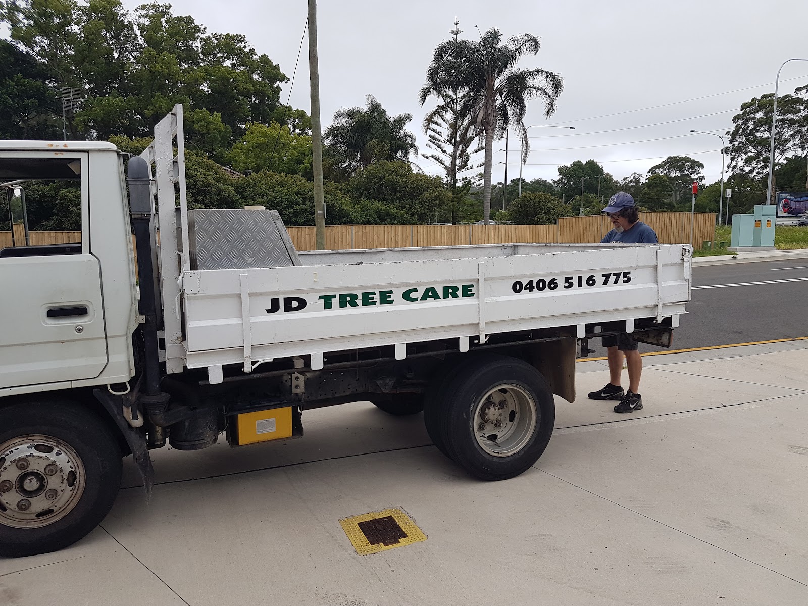 The white JD Tree Care tipper truck, signwritten with the business name and 0406 516 775